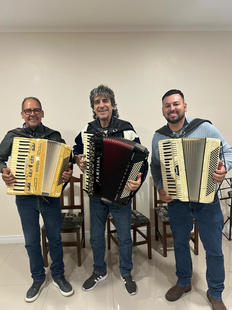 Trio de acordeonistas em apresentação da escola