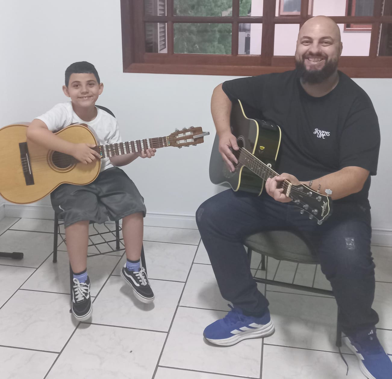 Aluno de violão com professor durante a aula