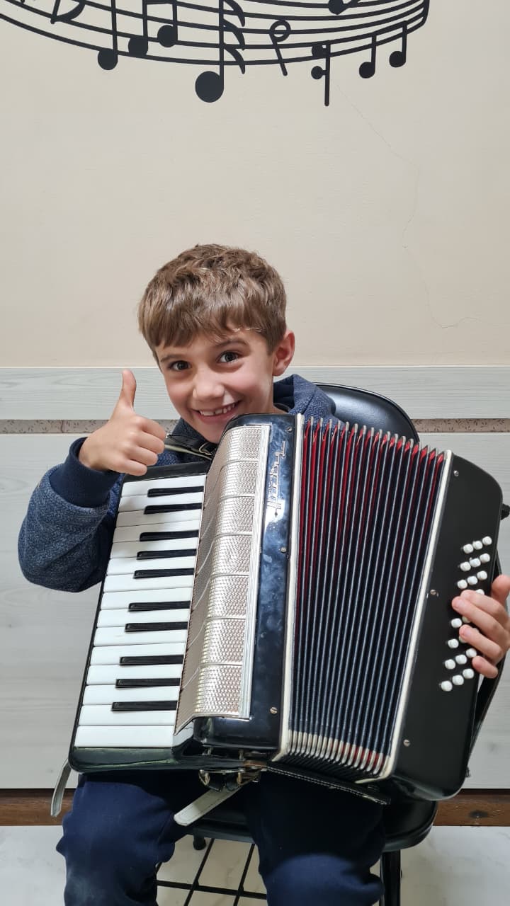 Criança tocando acordeon em aula no Portal Acordeon